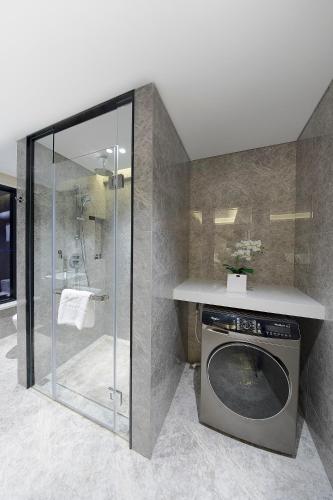 a washing machine in a bathroom with a shower at Shenzhen FY Hotel in Shenzhen
