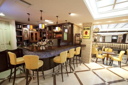 a bar in a restaurant with yellow bar stools at Akti Taygetos - Conference Resort in Kalamata