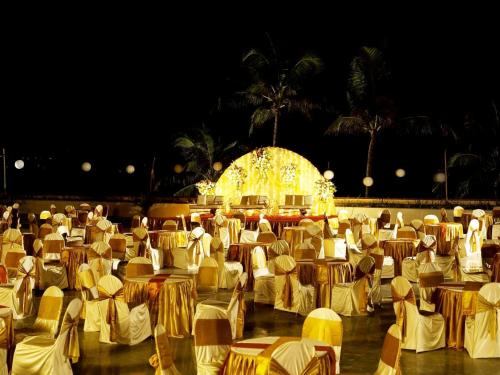a large room filled with tables and chairs at night at The Retreat Hotel & Convention Centre in Mumbai