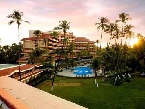 孟買的住宿－隱逸酒店及會議中心，享有度假村的空中景致,设有游泳池和棕榈树