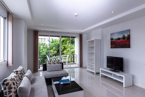 a living room with a couch and a television at Jomtien Beach Penthouses in Jomtien Beach