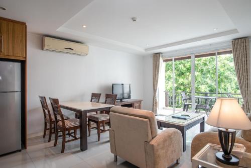 a living room with a table and chairs and a kitchen at Jomtien Beach Penthouses in Jomtien Beach