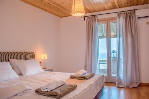 a bedroom with a bed with towels on it at Anastasis Luxury Villa Andros With Heated Pool in Sinétion
