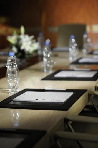 a table with two cell phones on a table with water bottles at Crowne Plaza - Dubai Jumeirah by IHG in Dubai