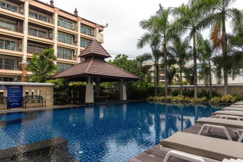 a swimming pool in front of a building at Jomtien Beach Penthouses in Jomtien Beach