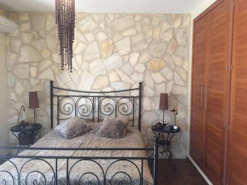 een slaapkamer met een bed en een stenen muur bij Casa Rural Lago Bolarque in Albalate de Zorita