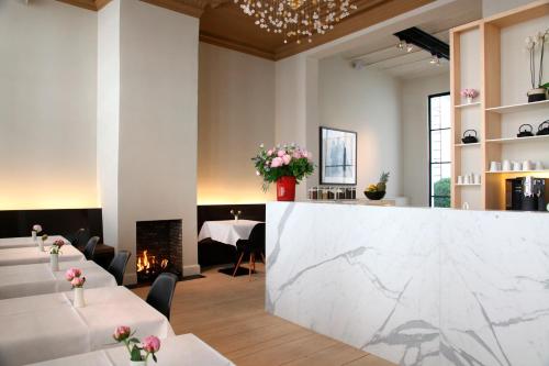 a restaurant with white tables and a marble counter at Hotel Julien in Antwerp