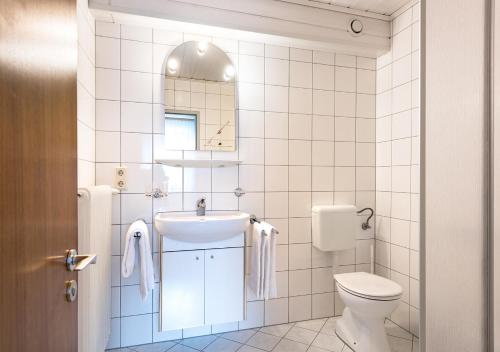 a white bathroom with a sink and a toilet at Appartementhaus Egga in Brand