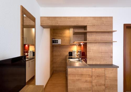 a kitchen with wooden cabinets and a counter top at Spirit Appartementhaus Egga in Brand