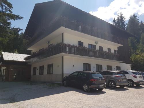 a large house with cars parked in front of it at Casa Alpina Dobbiaco in Dobbiaco