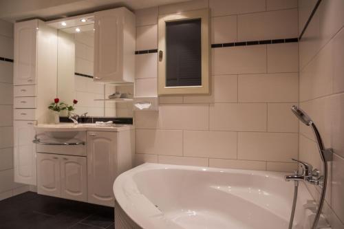 a white bathroom with a tub and a sink at Stolberger Hof in Stolberg i. Harz