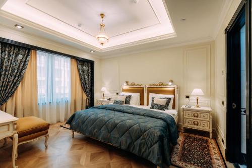 a bedroom with a large bed and a large window at Golden Palace Hotel Yerevan in Yerevan