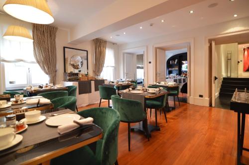 a dining room with tables and green chairs at Eight Hotel Portofino in Portofino