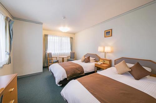 En eller flere senge i et værelse på Hotel Miyahira 
