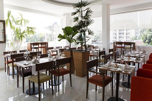 a restaurant with tables and chairs and a large window at Hotel Bella Riva Kinshasa in Kinshasa