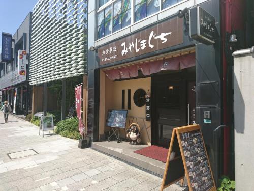 a dog sitting in the window of a store at Simple Stay Miyajima in Hatsukaichi