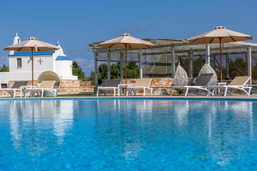 a large swimming pool with chairs and umbrellas at Sun and Moon Villas in Aliko Beach