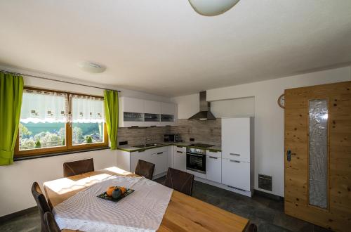a kitchen with a dining room table and a table and chairs at Alpenappart in Cadipietra