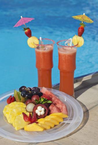 a plate of food on a table with two drinks at Al Manzel Hotel Apartments in Abu Dhabi