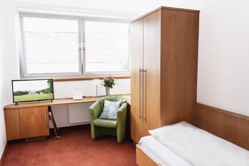 a bedroom with a desk and a bed and a chair at Landhotel Stegersbach in Stegersbach