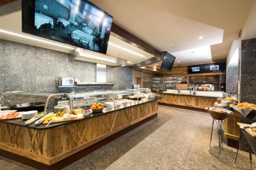 a restaurant with a buffet line with food on display at Berghotel Schmittenhöhe - 2000m in Zell am See