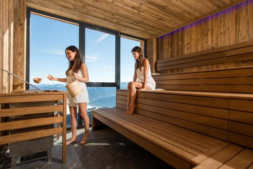 two women are standing in a sauna at Berghotel Schmittenhöhe - 2000m in Zell am See
