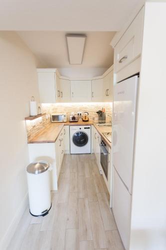 a kitchen with white cabinets and a refrigerator at Newcastle Court in Galway