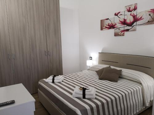 una camera da letto con un letto e due asciugamani di Tiny House Naxos a Giardini Naxos