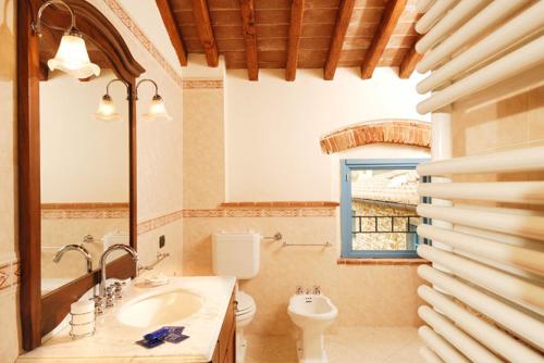 a bathroom with a sink and a toilet and a window at Podere Jana Antico Frantoio in Vinci