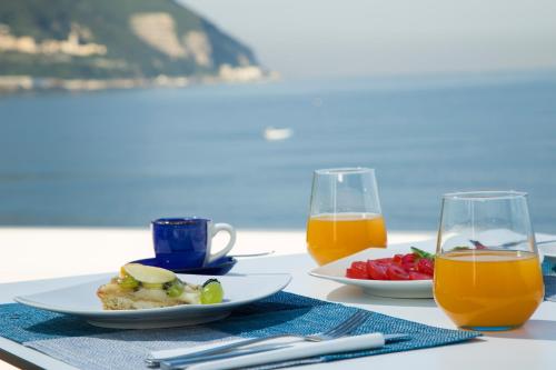 een tafel met een bord eten en twee glazen sinaasappelsap bij La Chiaja art&relais in Castellammare di Stabia