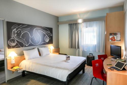 um quarto de hotel com uma cama e uma secretária com um computador em ibis Orange Sud em Orange