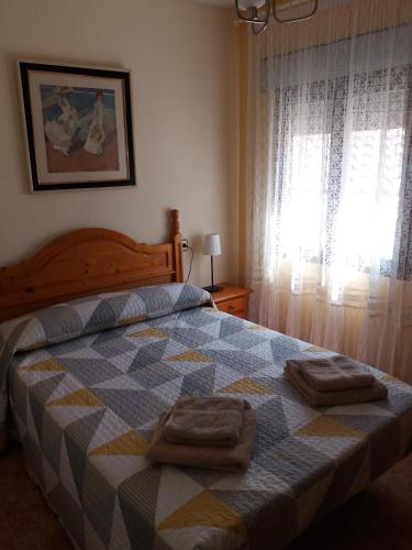 a bedroom with a bed with two towels on it at Casa El Reloj in Mombeltrán