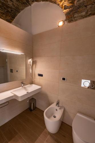 a bathroom with a sink and a toilet and a mirror at Olimpo Affittacamere in Manarola