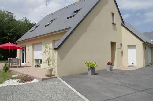 ein gelbes Gebäude mit einem roten Dach und einer Terrasse in der Unterkunft La Parquerie in Orval