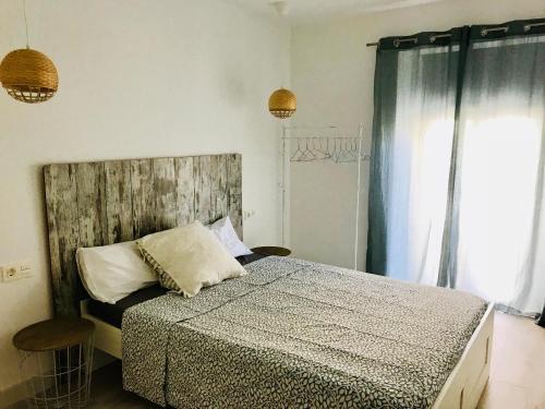 カンブリルスにあるEl Piset carrer Sant Jordiのベッドルーム1室(木製ヘッドボードと窓付)