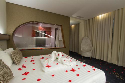 a hotel room with a bed with roses on it at Penafiel Park Hotel & Spa in Penafiel