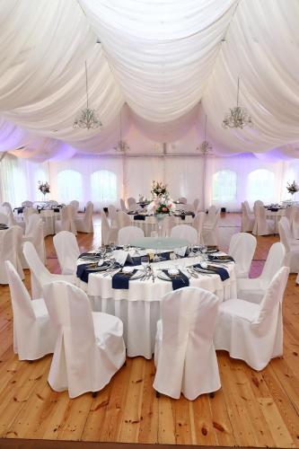 a room with white tables and chairs and white tents at Hotel Dwór Sójki in Sójki