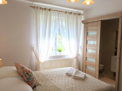 sypialnia z łóżkiem i oknem w obiekcie Olimpijska pokoje w Szczyrku