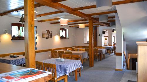 a dining room with tables and chairs and wooden beams at Tawerna Kaper in Iława