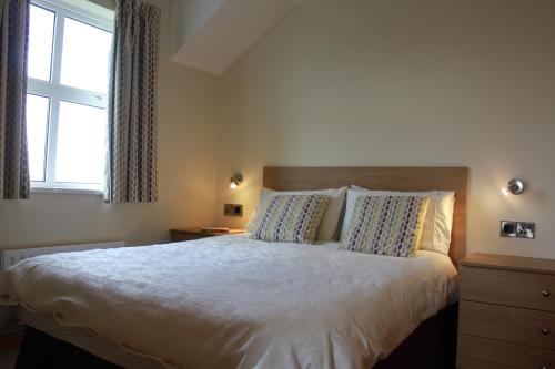 Un dormitorio con una cama grande y una ventana en Giant's Causeway Holiday Cottages, en Bushmills