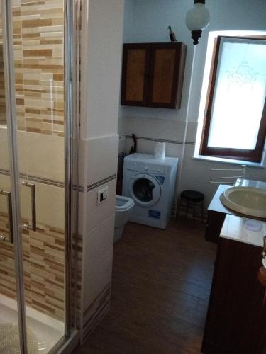 a bathroom with a toilet and a washing machine at Il Giardino Nascosto in Codiponte