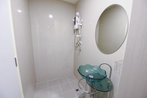 a white bathroom with a mirror and a sink at Wish Hotel Ubon in Ubon Ratchathani