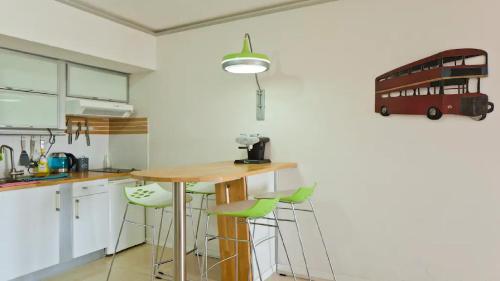 a kitchen with a table and a double decker bus on the wall at Luxury Sea View Apartment in Herzelia 