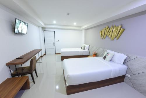 a bedroom with a bed and a desk and a table at Wish Hotel Ubon in Ubon Ratchathani