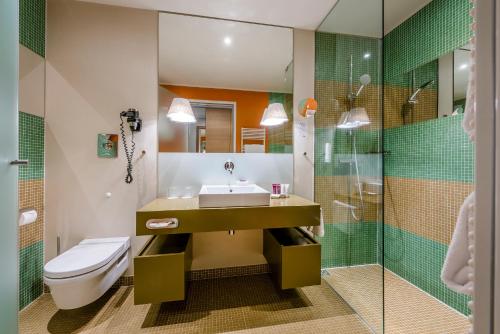 a bathroom with a sink and a toilet and a shower at Hotel Therme Meran - Terme Merano in Merano