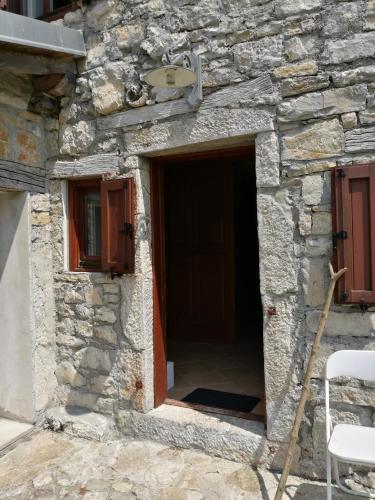 a stone building with a door and two windows at Holiday Farmhouse Skvor in Robidišče