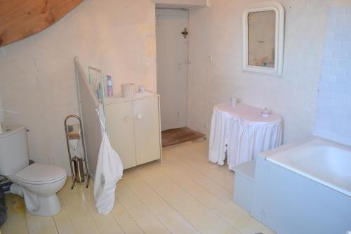 a white bathroom with a toilet and a sink at Le Petit Logis in Rouillac