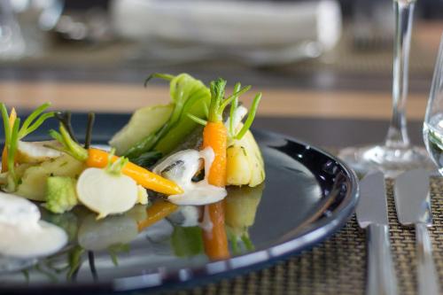 a plate of food with vegetables on a table at Penafiel Park Hotel & Spa in Penafiel