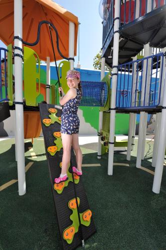 a young girl is standing on a slide at a playground at Spring Hotel Bitácora in Playa de las Americas