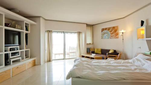 1 dormitorio con 1 cama y sala de estar en Luxury Sea View Apartment en Herzelia 